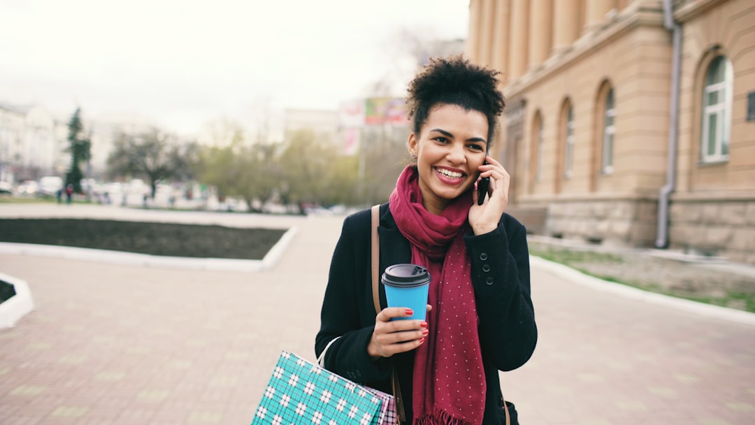 Klientka z zakupami rozmawia przez telefon na ulicy